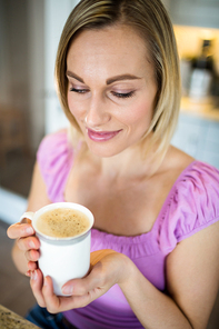 Pretty blonde woman having coffee at home