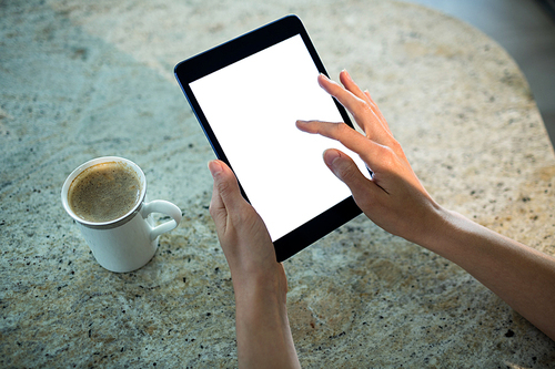 Pretty blonde woman using tablet computer at home