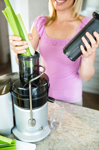 Woman preparing a smoothie in the kitchen at home