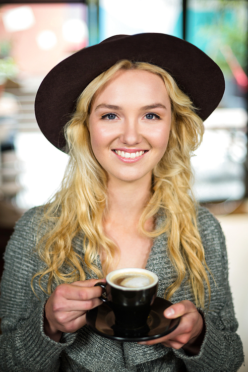 Smiling blonde drinking a coffee at the coffee shop