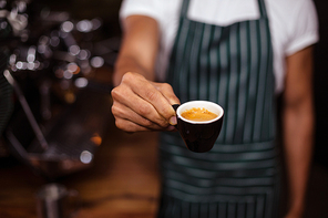 Barista offering an espresso in the coffee shop