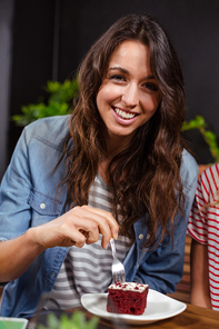 Smiling brunette enjoying a pastry at the coffee shop