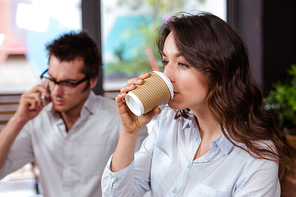People using smartphone and drinking coffee in a cafe