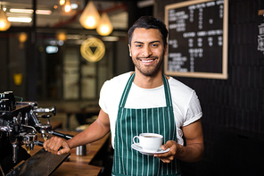 Smiling barista making coffee with coffee machine in the bar
