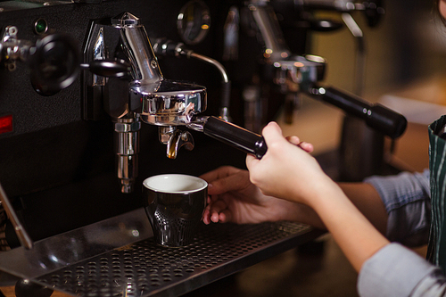 Close up of barista using coffee machine in the bar