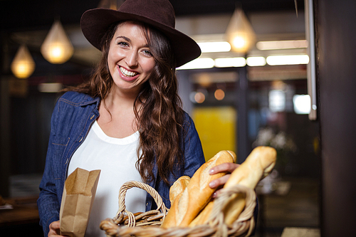 Smiling woman touching bread and looking at the camera in the bar