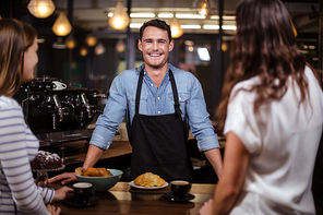 Smiling barista looking at the camera in the bar