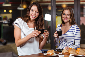Smiling friends having coffee at the bar
