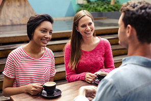 Happy friends having coffee together at the bar