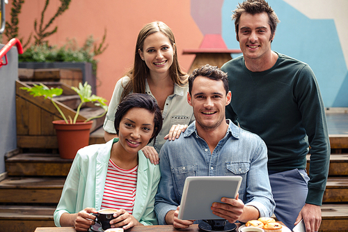 Happy friends using tablet at the bar