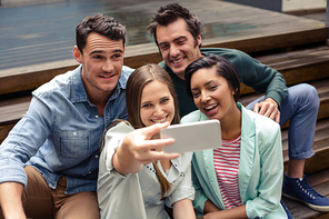 Happy friends taking selfie outside the bar