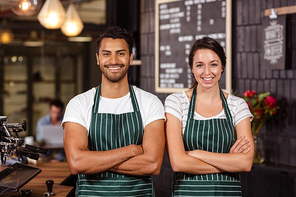 Smiling baristas standing with arms crossed and looking at the camera