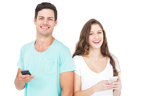 Smiling couple using their smartphones on white background