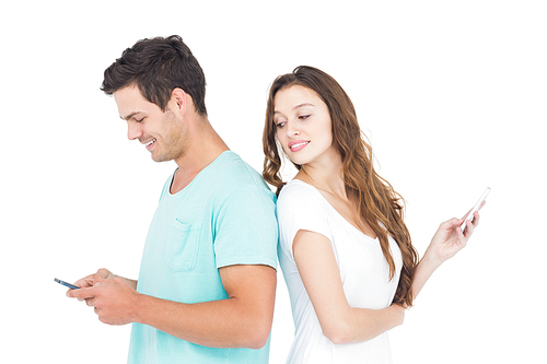 Smiling couple using their smartphones back to back on white background