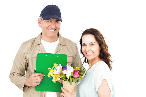 Female customer signing on paper with delivery man on white background