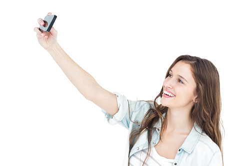 Smiling young woman taking a selfie on white background
