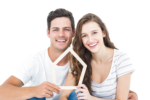 Happy couple holding house shape on white background