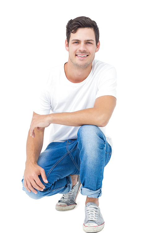 Handsome man crouching on white background
