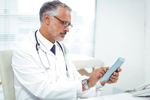 Doctor using digital tablet at clinic