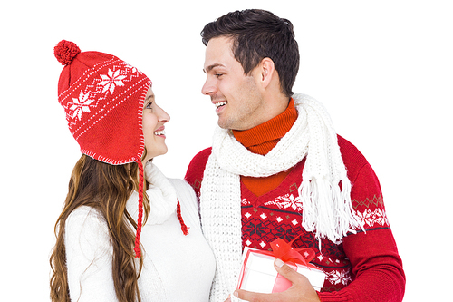 Happy couple with winter clothes holding gift box on white backgrond