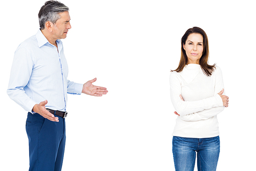 Couple arguing while standing against white background