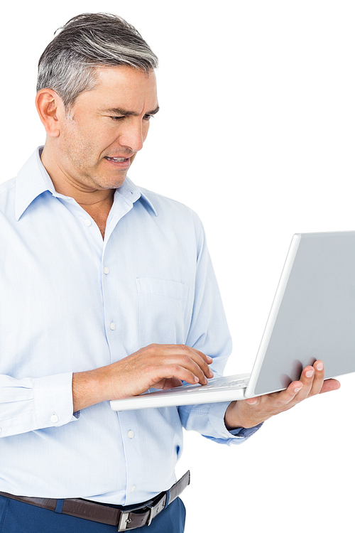 Smiling businessman typing on laptop on white background