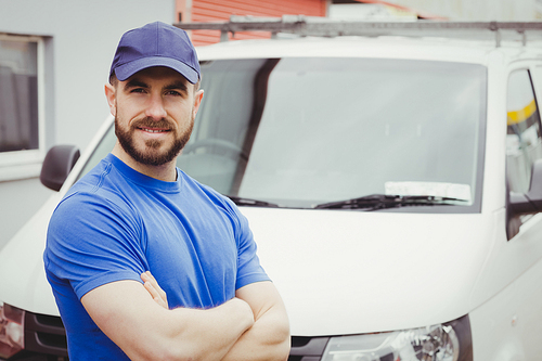 Man standing with arms crossed in front of his van