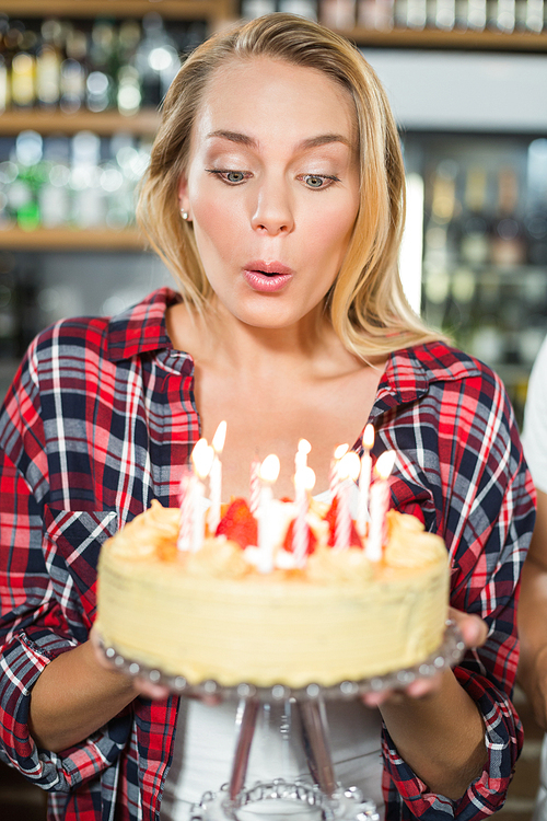 Woman blowing out candles on a cake