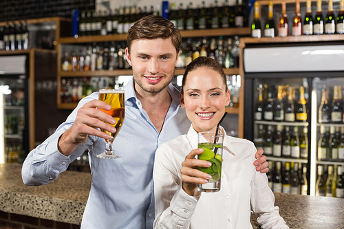 Attractive woman and man hugging with beverages in hands