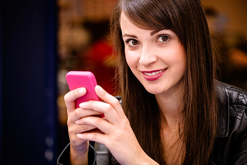 Portrait of beautiful woman using mobile phone in a shop
