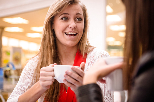 Woman talking while having coffee in coffee shop