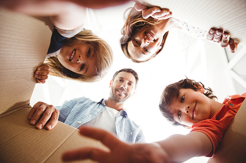 Directly below shot of smiling family with cardboard boxes