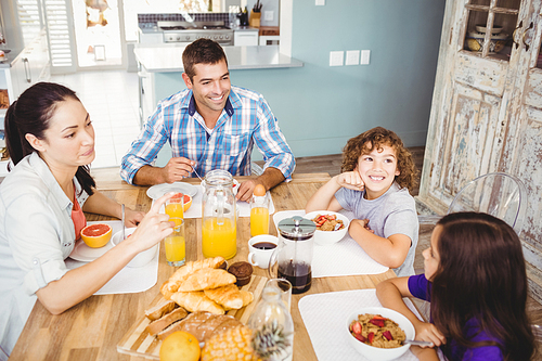 High angle view of happy family eating breakfast at table in house