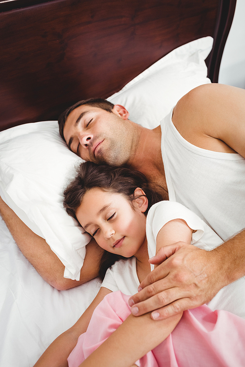 High angle view of daughter sleeping beside father on bed at home