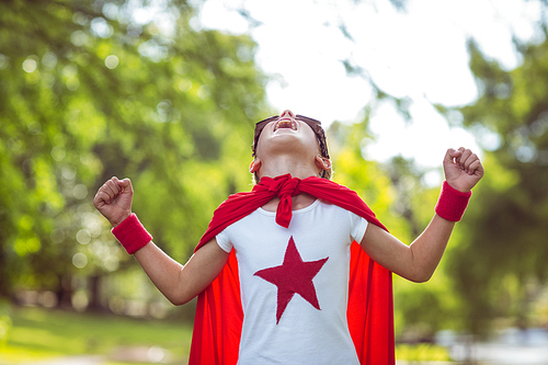 Little boy dressed as superman in the garden