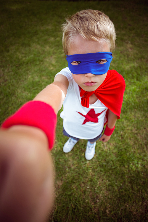 Little boy dressed as superman in the garden