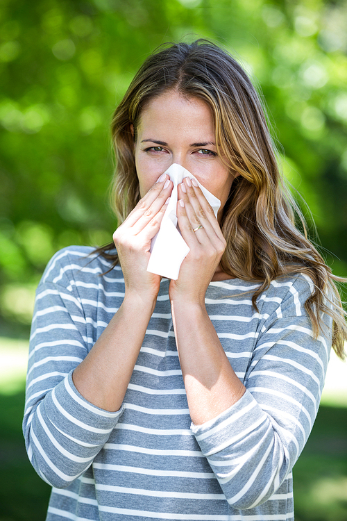 Woman using a tissue in a park