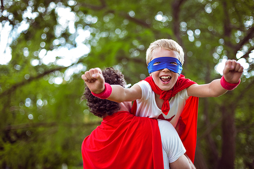 Father and son dressed as superman in the garden