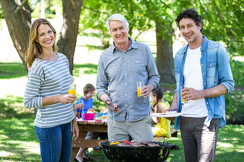 Family having a picnic with barbecue in a park