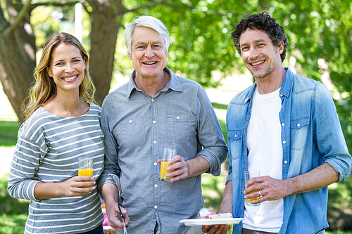 Family having a picnic with barbecue in a park