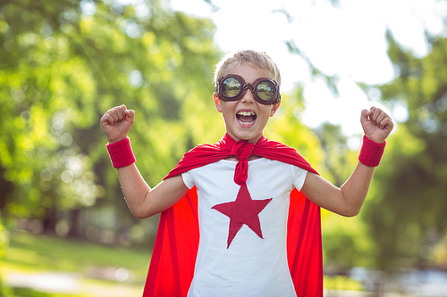 Little boy dressed as superman in the garden
