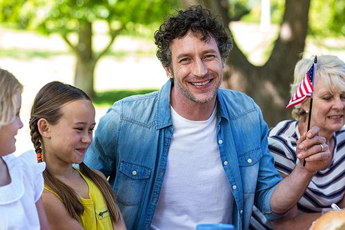 Family with American flag having a picnic in a park