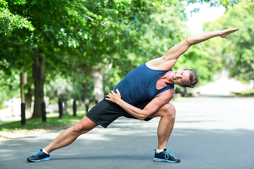 Sportsman stretching in park on a sunny day