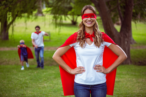 Happy family pretending to be superhero in the park