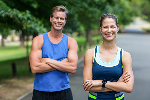 Fit people posing with crossed arms in park