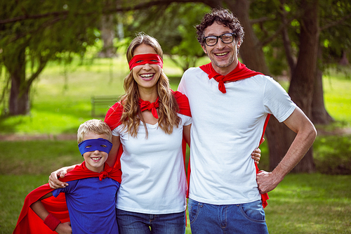 Happy family pretending to be superhero in the park