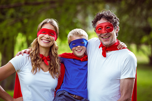 Happy family pretending to be superhero in the park