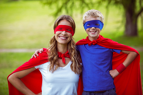 Mother and son pretending to be superhero in park