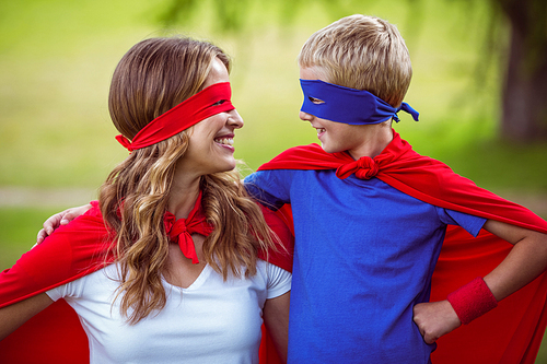 Mother and son pretending to be superhero in park