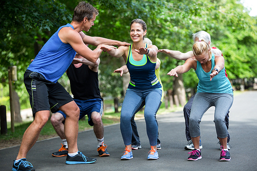 Fitness class doing squat sequence in the park